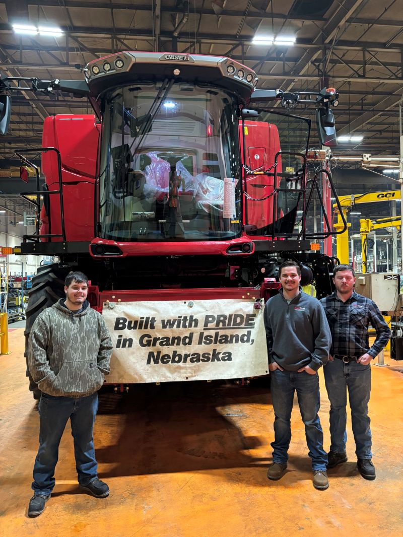 Ben Rodkey, Gavin Hook and Jon Neff in front of a new AF10 combine at the Grand Island factory
