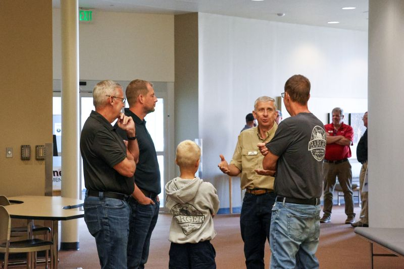 Customers and Redline staff talk in a hallway at a Harvest Ready event